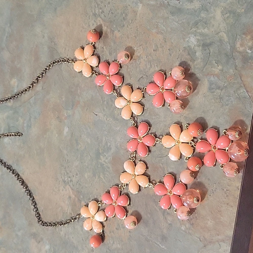 Make a statement with this 16" long coral colored flower necklace